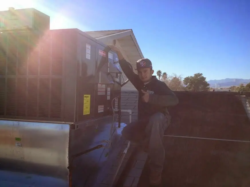 HVAC technician performing Air Duct Cleaning on a rooftop unit in Presque Isle
